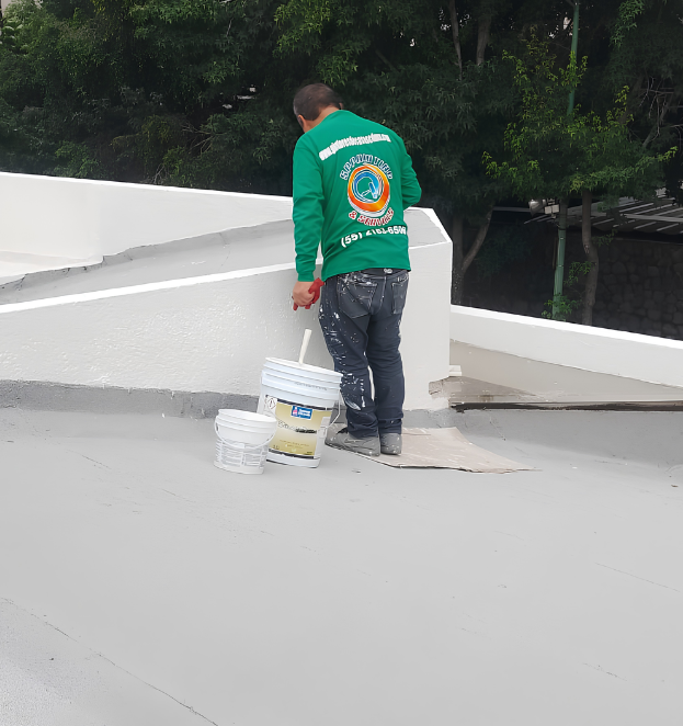 Pintores de exteriores aplicando pintura en fachada residencial